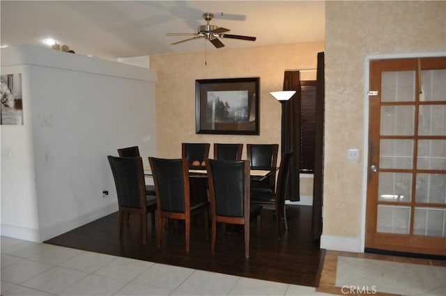 tiled dining room featuring baseboards and a ceiling fan