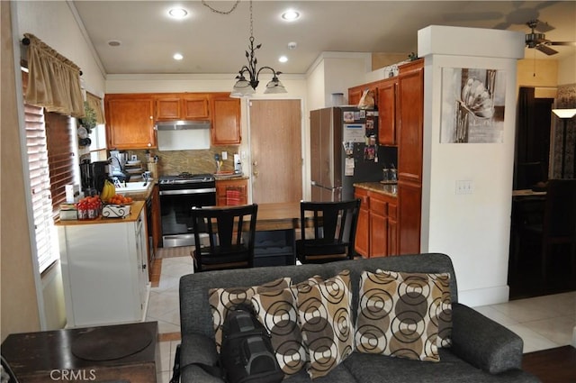 kitchen with backsplash, ornamental molding, light tile patterned floors, stainless steel appliances, and a ceiling fan