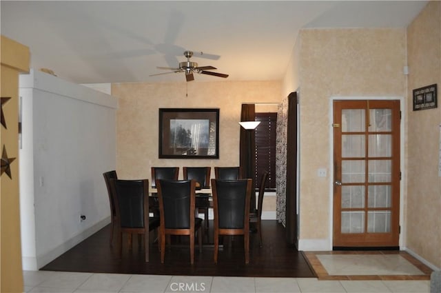 tiled dining room with baseboards and a ceiling fan