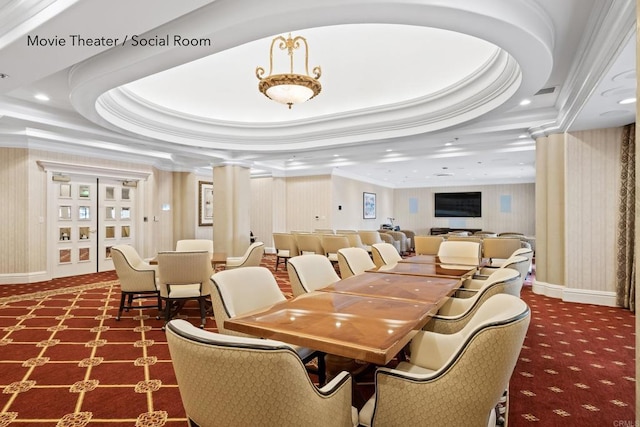 carpeted dining area featuring decorative columns, a raised ceiling, baseboards, and crown molding