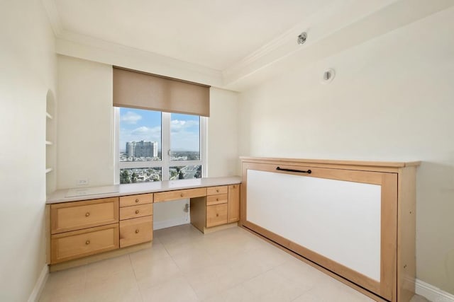 home office featuring crown molding, a view of city, baseboards, and built in desk