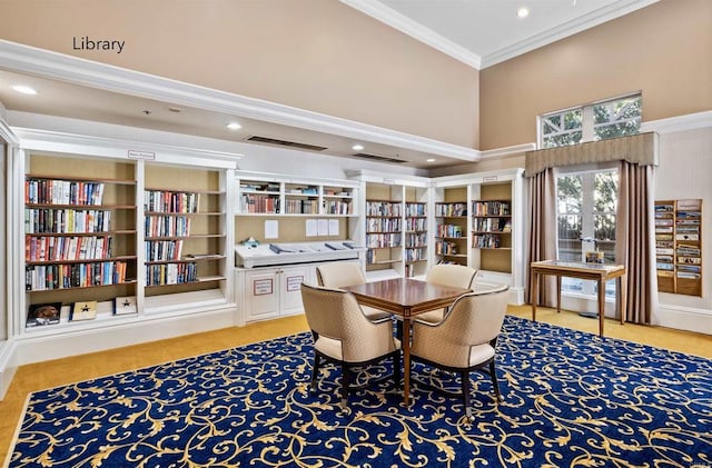 dining room with recessed lighting, a high ceiling, and ornamental molding