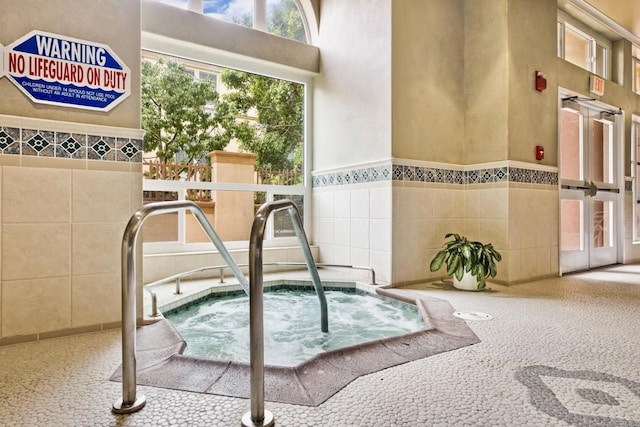 view of swimming pool featuring an indoor hot tub