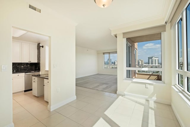 interior space with light tile patterned floors, baseboards, visible vents, a view of city, and light colored carpet