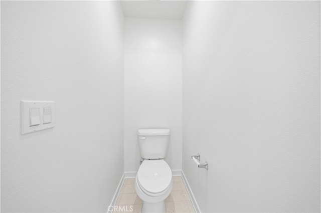 bathroom featuring baseboards, toilet, and tile patterned flooring