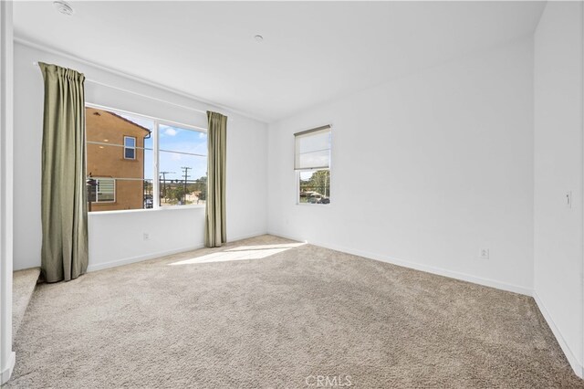empty room with carpet and baseboards