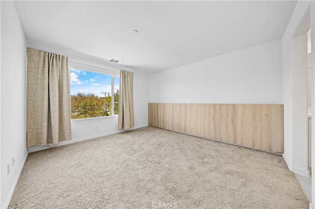 carpeted empty room with visible vents and baseboards