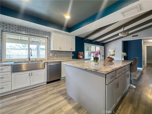 kitchen with visible vents, a sink, stainless steel dishwasher, and light wood finished floors