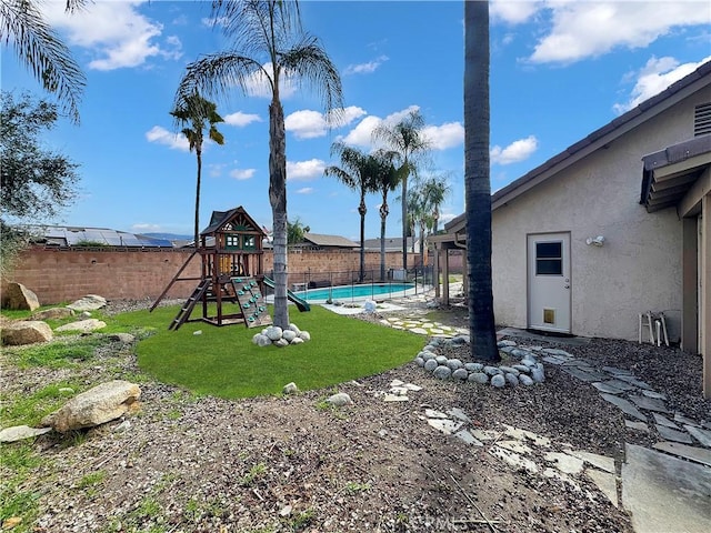 view of yard with a patio, a fenced in pool, a fenced backyard, and a playground