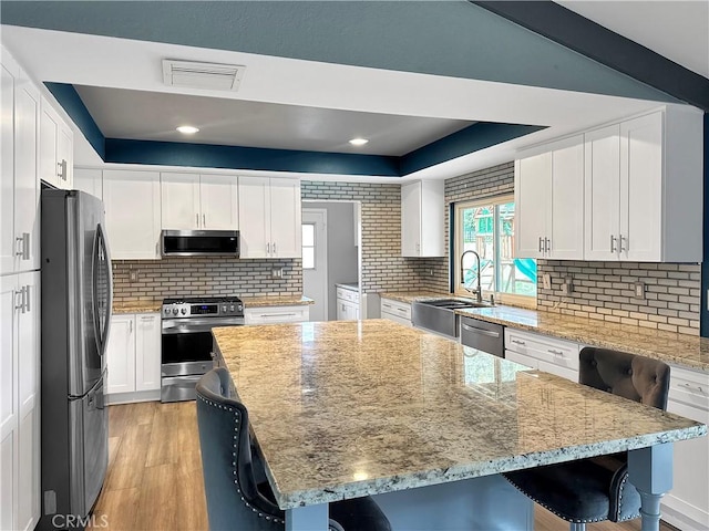 kitchen featuring visible vents, light wood-style floors, white cabinetry, and stainless steel appliances
