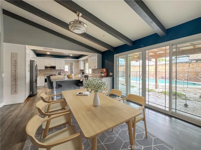 dining area featuring light wood-style flooring, lofted ceiling with beams, and a wealth of natural light