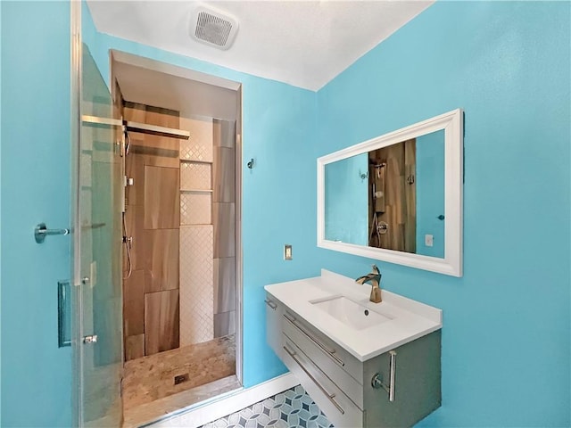 bathroom featuring visible vents, a stall shower, and vanity