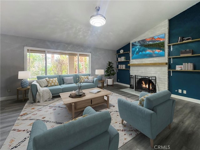 living room with baseboards, lofted ceiling, a fireplace, and wood finished floors