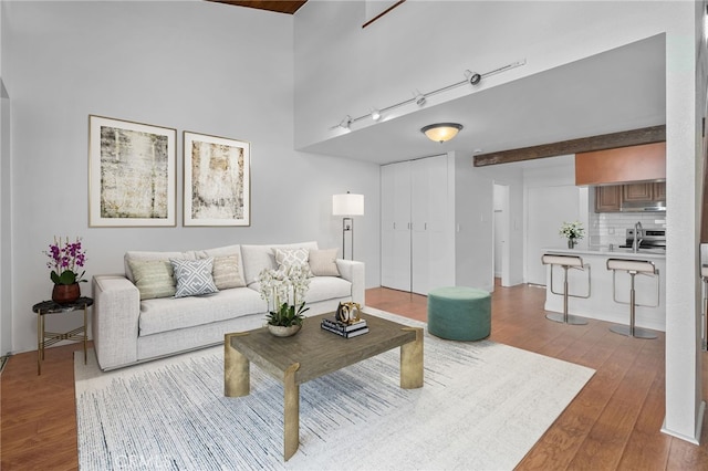 living area with wood finished floors and a towering ceiling