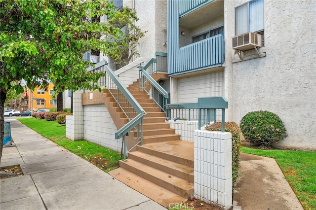 view of exterior entry with cooling unit and stucco siding