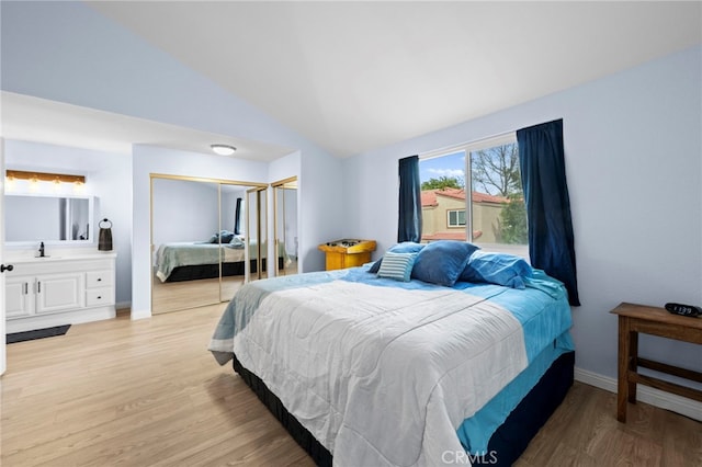 1330 Vista Grande Unit 27, Fullerton, CA 92835 - bedroom with vaulted ceiling, light wood-type flooring, a sink, a closet, and baseboards