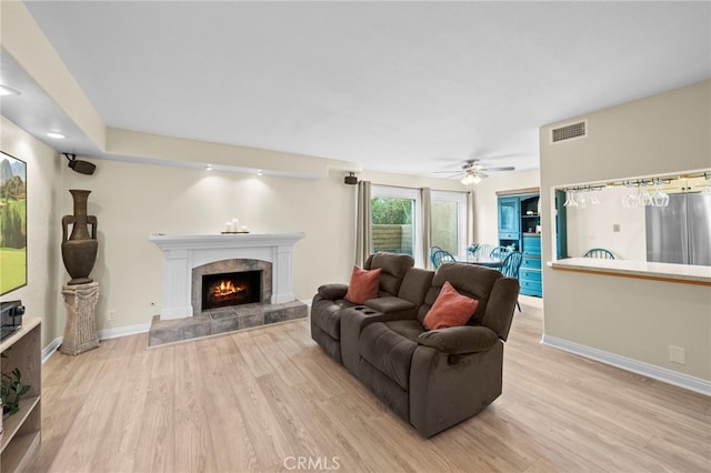 1330 Vista Grande Unit 27, Fullerton, CA 92835 - living area with light wood-style floors, a tiled fireplace, ceiling fan, and baseboards