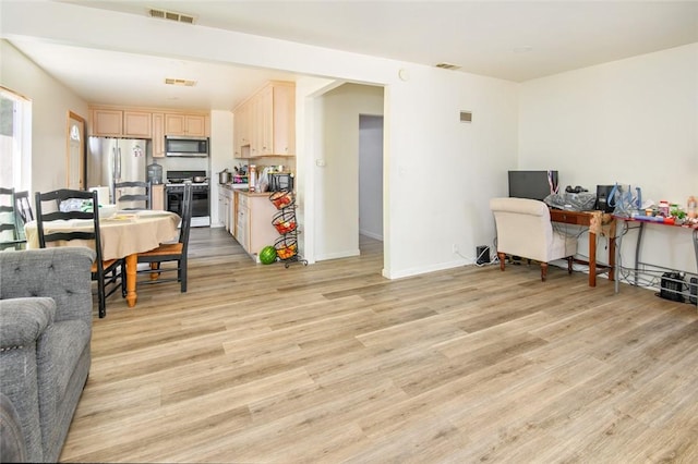 interior space featuring open floor plan, light wood-style floors, visible vents, and stainless steel appliances