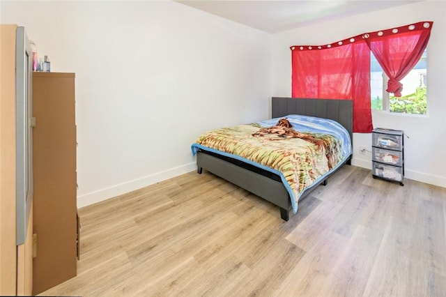 bedroom featuring wood finished floors and baseboards