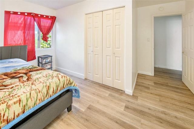 bedroom featuring wood finished floors, a closet, and baseboards