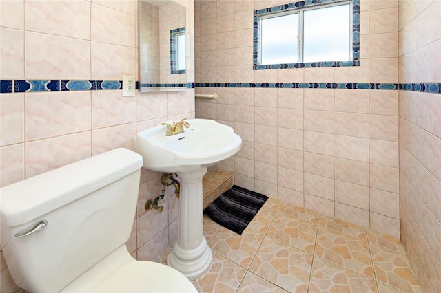 bathroom featuring toilet and tile walls