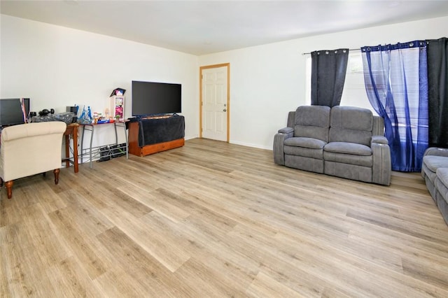 living area with baseboards and light wood finished floors