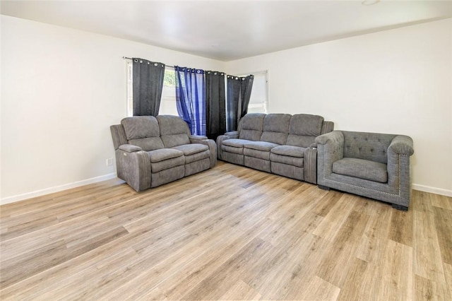 living area with light wood-type flooring and baseboards