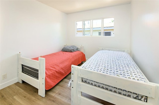 bedroom featuring baseboards and light wood-style flooring