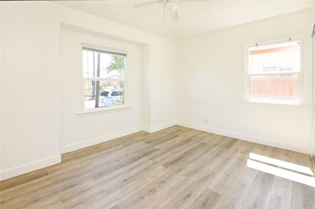 unfurnished room featuring a ceiling fan, light wood-style floors, and baseboards