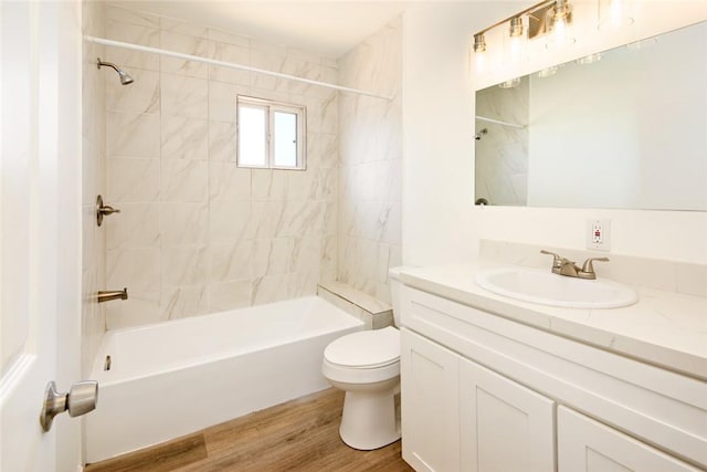 bathroom with vanity, toilet, wood finished floors, and shower / washtub combination