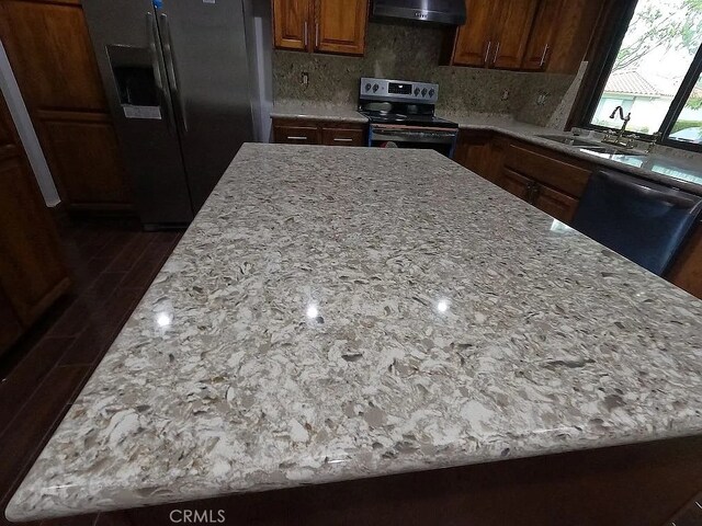 28132 Via Congora, Mission Viejo, CA 92692 - kitchen with a kitchen island, appliances with stainless steel finishes, tasteful backsplash, light stone countertops, and under cabinet range hood