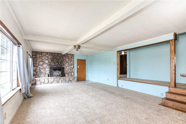 unfurnished living room with beam ceiling, carpet flooring, a textured ceiling, and ceiling fan