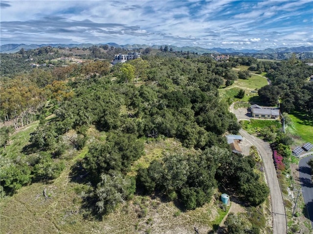 birds eye view of property featuring a mountain view and a wooded view