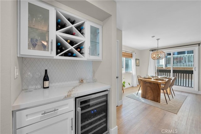 2204 Vanderbilt Ln Unit 16, Redondo Beach, CA 90278 - bar with tasteful backsplash, wine cooler, a bar, baseboards, and light wood-style floors
