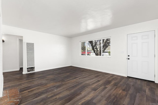 spare room with dark wood-type flooring and baseboards