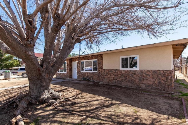 single story home with fence, stone siding, and stucco siding