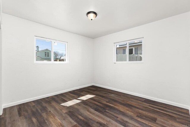 empty room featuring wood finished floors and baseboards