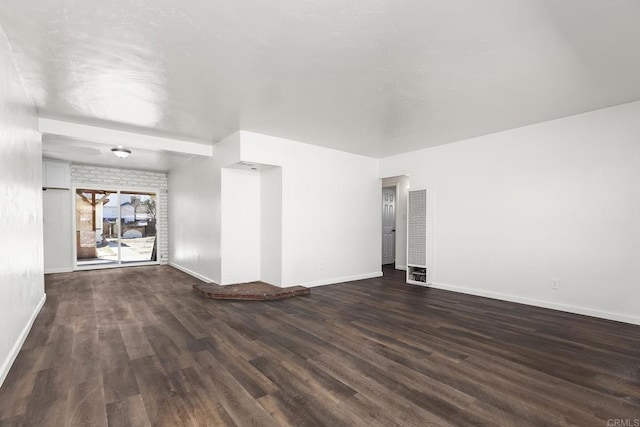 empty room with visible vents, baseboards, and dark wood-style flooring