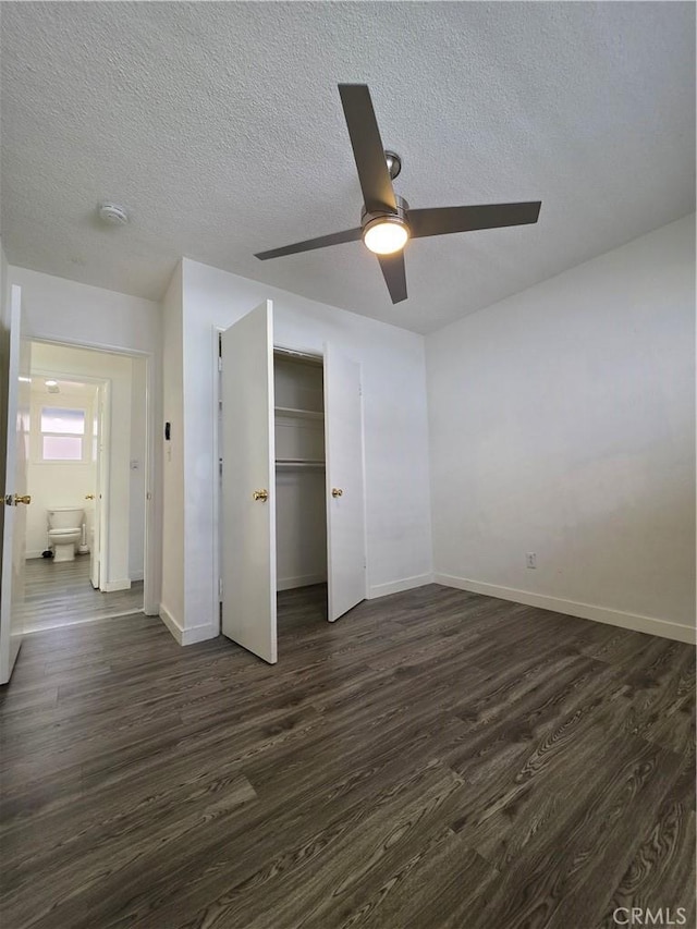 unfurnished bedroom featuring a textured ceiling, dark wood-style floors, a closet, baseboards, and ceiling fan