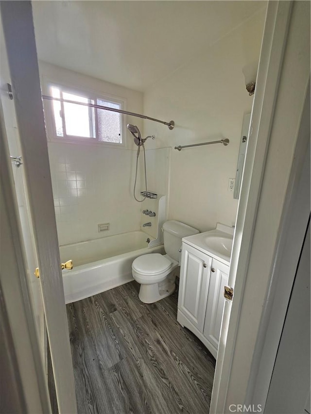 full bathroom featuring washtub / shower combination, toilet, wood finished floors, and vanity