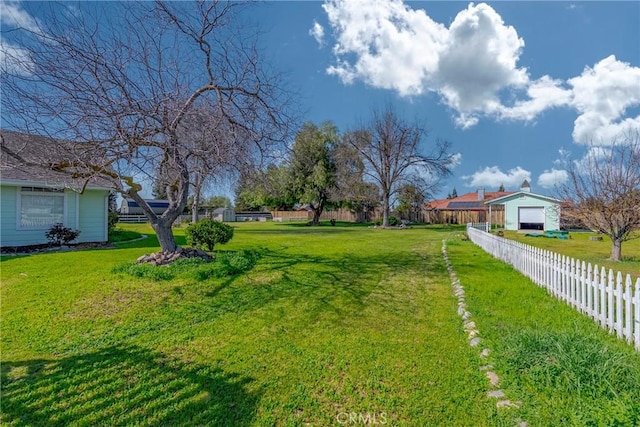 view of yard featuring a garage and a fenced backyard