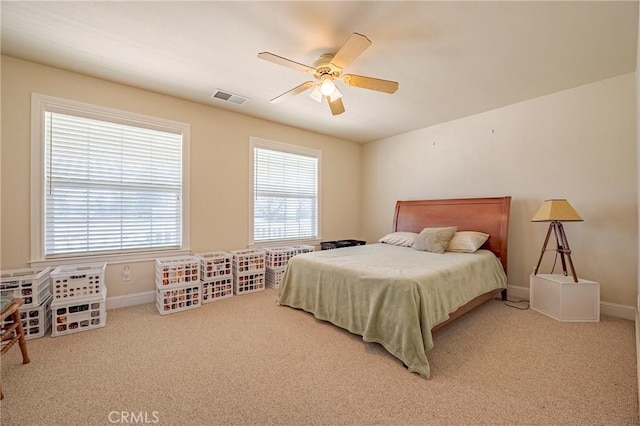 carpeted bedroom featuring visible vents, a ceiling fan, and baseboards