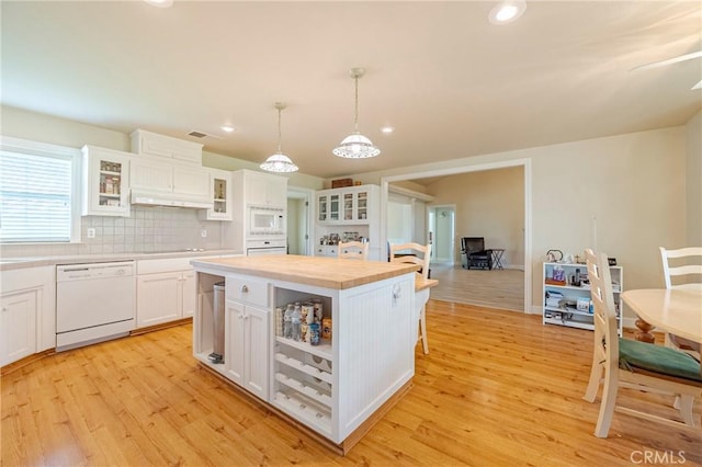 kitchen featuring backsplash, white appliances, light wood-style floors, and white cabinetry