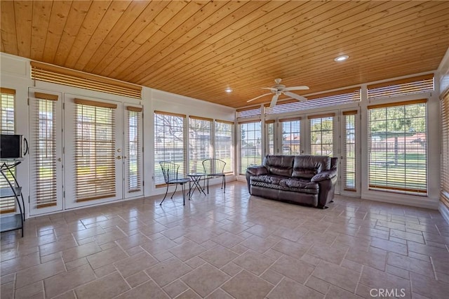 unfurnished sunroom with wooden ceiling, plenty of natural light, and a ceiling fan