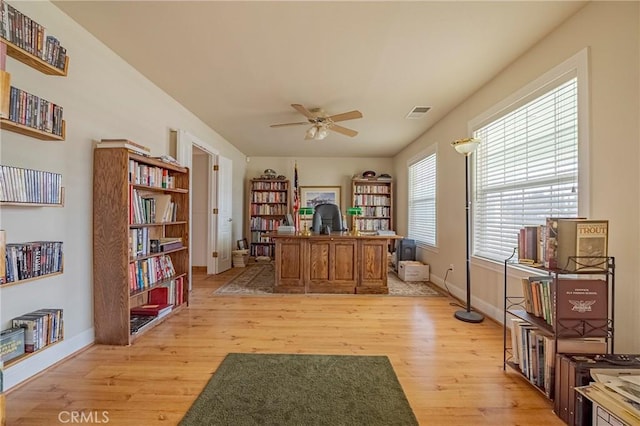 office featuring light wood finished floors, visible vents, baseboards, and ceiling fan