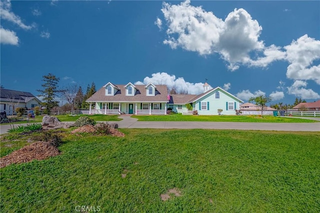 view of front of house with a front yard, a porch, and fence