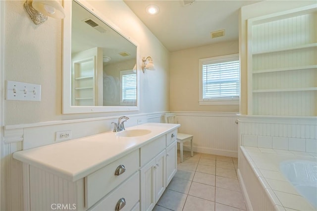 full bathroom with built in features, plenty of natural light, visible vents, and wainscoting