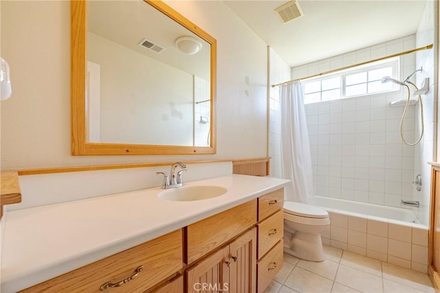 bathroom with tiled shower / bath combo, visible vents, toilet, and tile patterned flooring