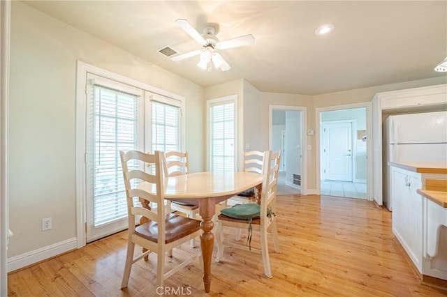 dining space featuring visible vents, baseboards, light wood-style floors, and a ceiling fan