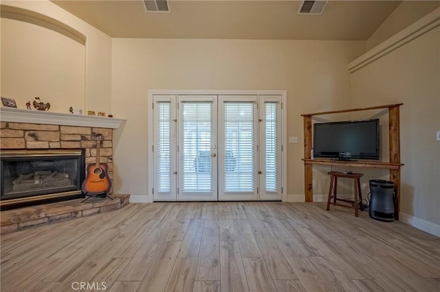 unfurnished living room with visible vents, baseboards, and wood finished floors